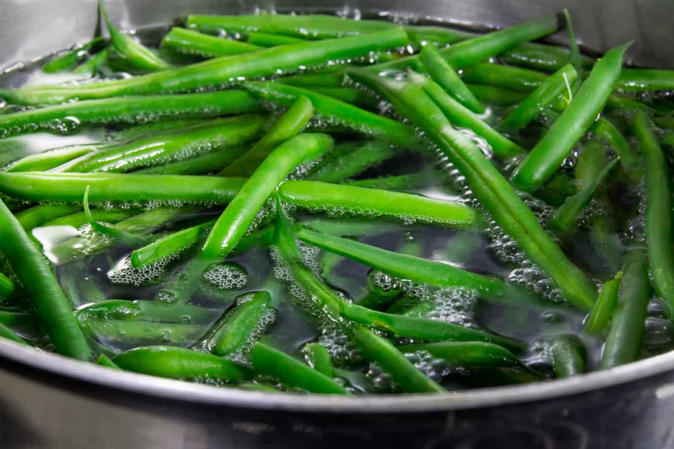 Green beans in a bowl with cold water