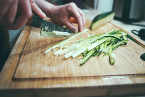 Cucumber being sliced into rectangles